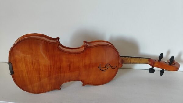 "Fondo de violín de autor con arce muy rizado, detalle de clave de sol grabada y acabado en barniz al aceite antiqued."